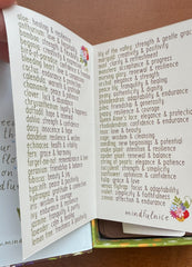 Open book with text and floral designs on a wooden surface
