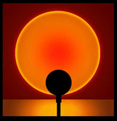 Solar eclipse with a silhouette of a tree against a red and orange sky