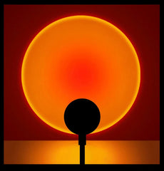 Solar eclipse with a silhouette of a tree against a red and orange sky