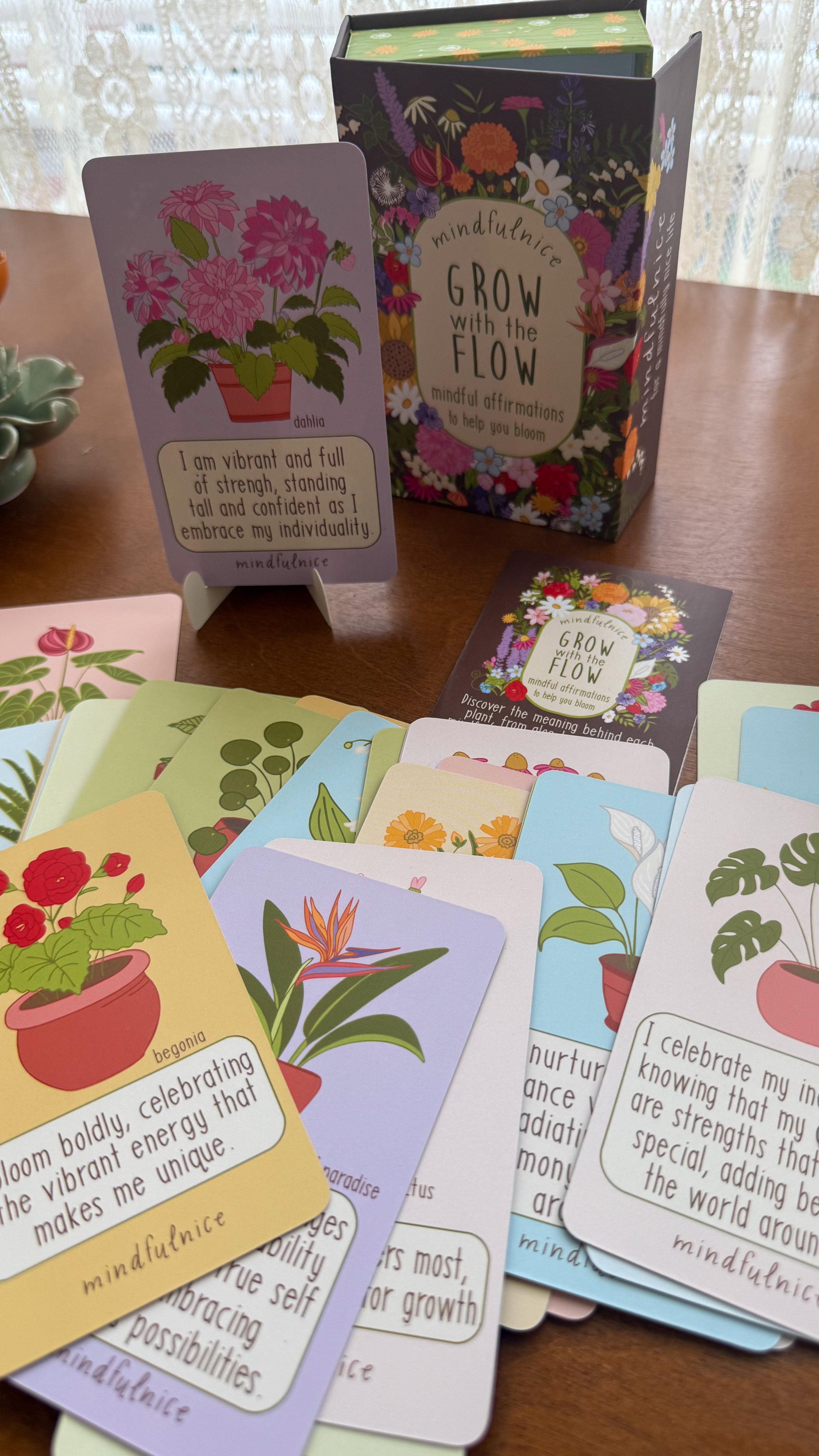 Set of cards with floral designs and motivational text on a wooden surface.