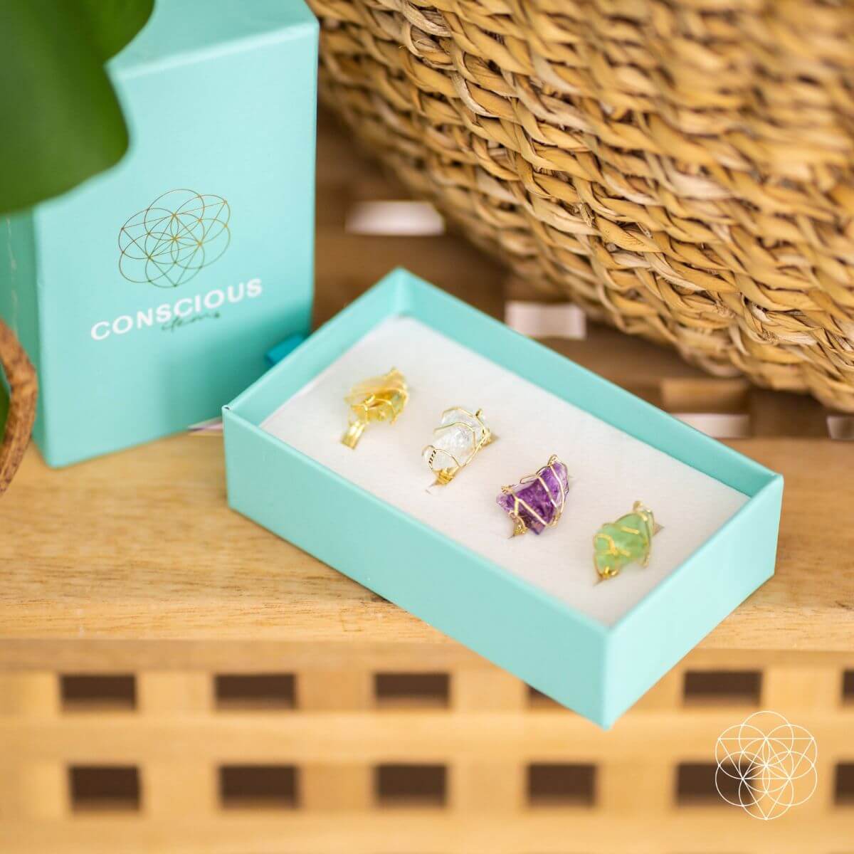 Set of earrings in a turquoise box with 'Conscious' branding on a wooden surface.